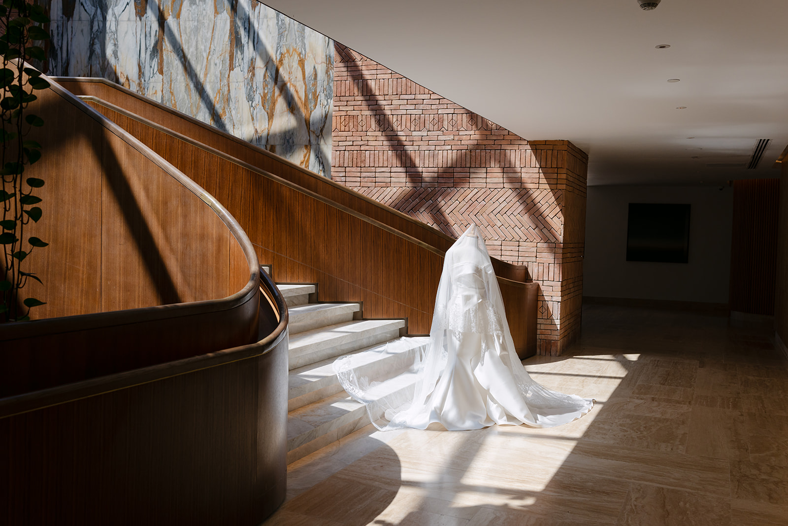 The bride's gown and lace-trimmed veil cascading down the marble staircase at the St. Regis Cap Cana